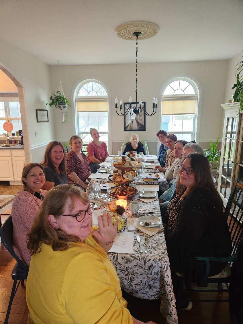 Congregation members and guests gathered around a fellowship table at Life of Faith Gospel Ministries